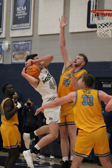 Fort Lewis senior forward Brendan La Rose (32) attempts to block a shot attempt by Mines junior forward Riley Schroeder (44) during the Jan. 27 game at Colorado School of Mines.